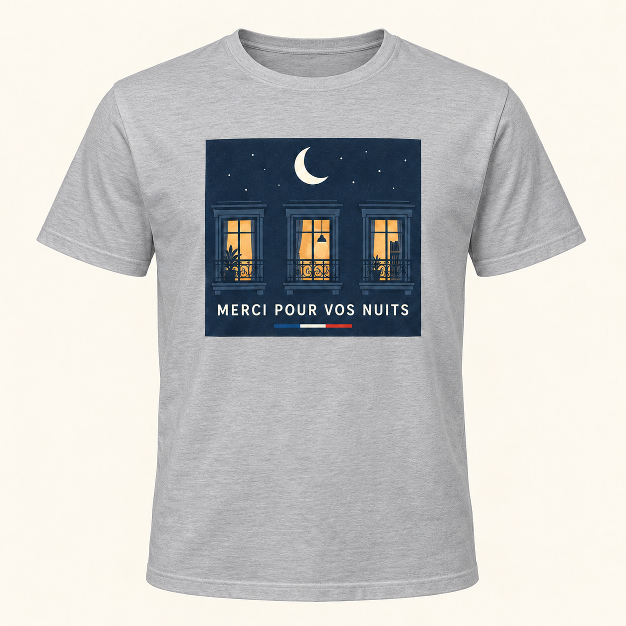 T-shirt gris avec « MERCI POUR VOS NUITS » en lettres ivoire sur un panneau rectangulaire bleu nuit, une lune et trois fenêtres éclairées; trait tricolore sous le panneau, sur le devant.