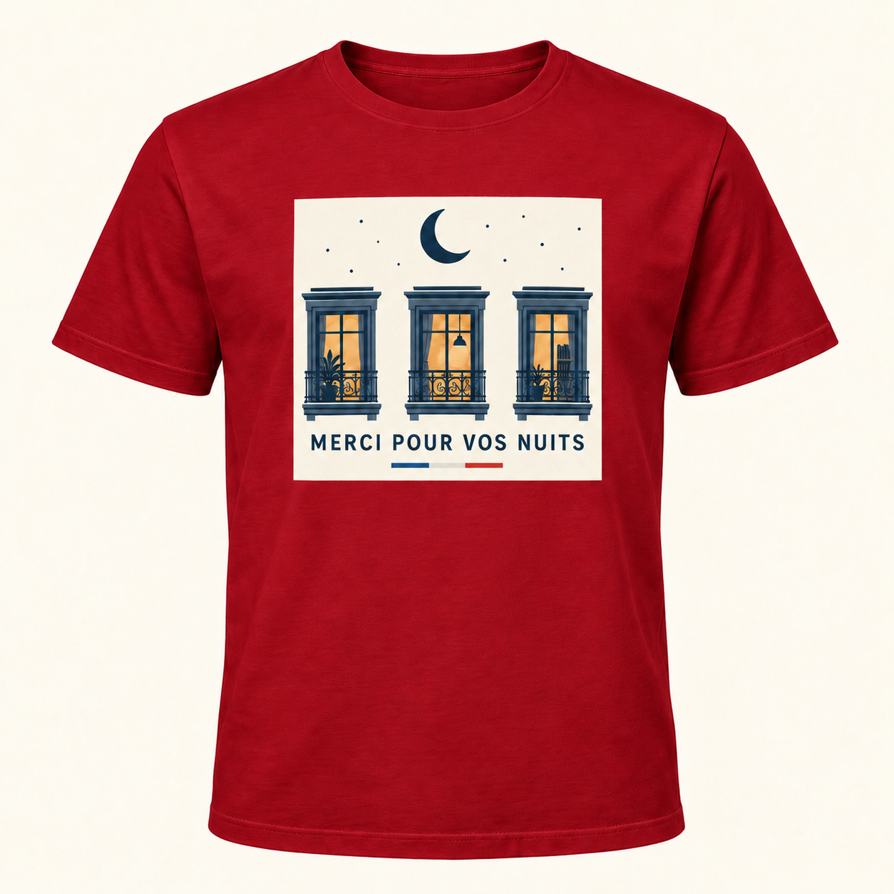 T-shirt rouge avec « MERCI POUR VOS NUITS » en bleu marine sur un panneau rectangulaire ivoire, une lune et trois fenêtres éclairées; trait tricolore sous le panneau, sur le devant.